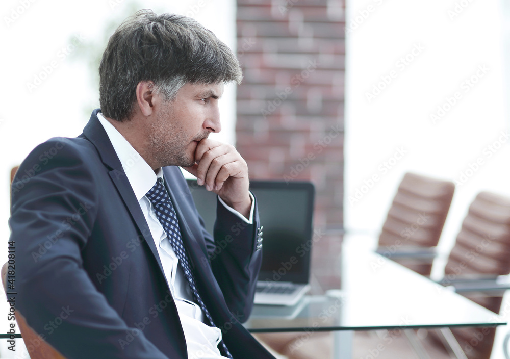 Wall mural pensive businessman sitting at office desk in office