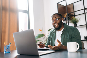Distance learning at home, online working. African American guy student or freelancer uses a laptop for learning or working, having video conference
