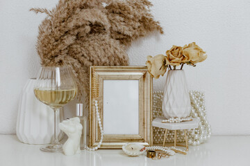 Feminine Mockup vintage gold frame with fluffy branches of dried flowers, white wine, candle. Wedding still life. Cozy Aesthetic Background. Parisian chic