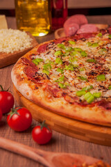 Pizza with calabrese sausage, mozzarella cheese, onion and green bell pepper - Traditional brazilian pizza de calabresa - Closeup.