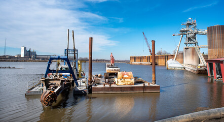 Towboat pushing dry bulk cargo barge under bridges up Mississippi River. Shipping grain corn during...