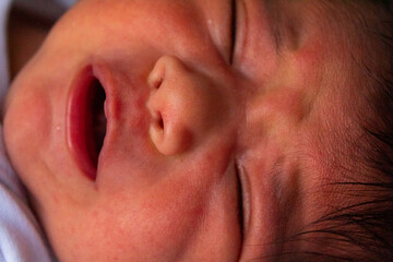 close up of the face of a newborn hispanic baby