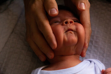 hands of a man playfully playing with a newborn baby