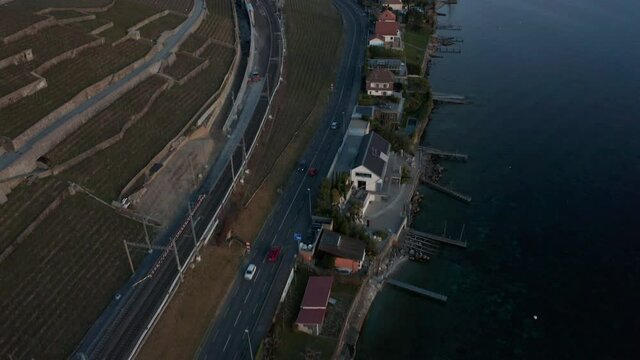 Aerial of traffic driving over highway, tilting up and revealing stunning vast lake