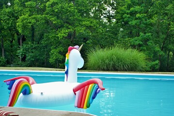 unicorn inflatable floating in a backyard swimming pool © PictureThisImages