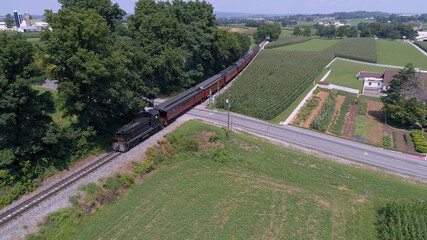 Aerial View of An Antique Restored Diesel Locomotive Traveling Thru Farmlands and Countryside on a Sunny Summer Day