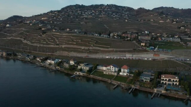 Aerial of train driving through beautiful Swiss landscape. Filmed in Cully, Switzerland