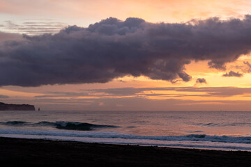 Intense sunrise at the beach in Chiba Japan, this beach is famous for surfing and is close to a place where surfing competitions in Japan are held. The colors in the sky are orange and yellow.
