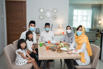 portrait of happy family muslim wear mask during eid mubarak celebration at home