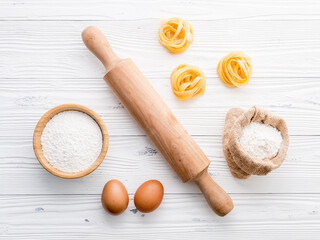 Ingredients for homemade pasta  flour and eggs on wooden background.