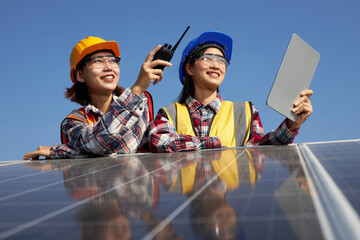 A female electrical engineer chatting outdoors at the solar panel.