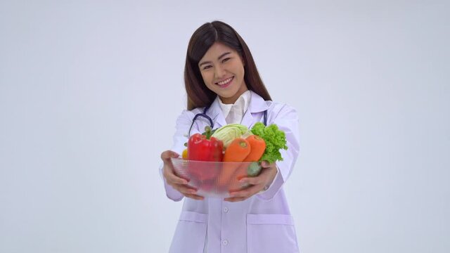 Doctor or nutritionist holding fresh fruit and smile in a clinic. Healthy diet concept of nutrition food as a prescription for good health, the fruit is medicine