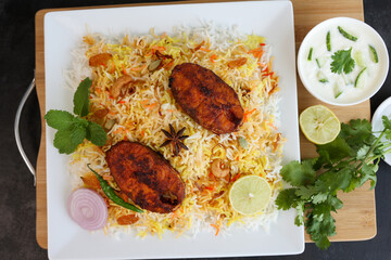 Fish biryani , Spicy and delicious Malabar biryani or Hyderabadi biryani, Dum Biriyani, pulao Kerala India Sri Lanka . basmati rice, herbs, raitha for Ramadan Kareem, Eid
