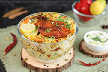 Fish biryani , Spicy and delicious Malabar biryani or Hyderabadi biryani, Dum Biriyani, pulao Kerala India Sri Lanka . basmati rice, herbs, raitha for Ramadan Kareem, Eid