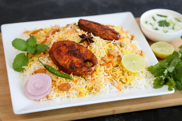 Fish biryani , Spicy and delicious Malabar biryani or Hyderabadi biryani, Dum Biriyani, pulao Kerala India Sri Lanka . basmati rice, herbs, raitha for Ramadan Kareem, Eid