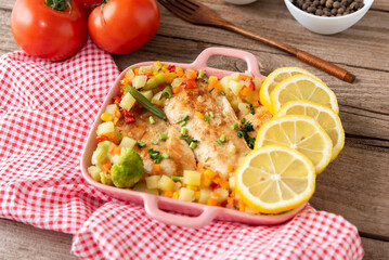 Baked homemade chicken from the oven with vegetables and lemon. Tableware. Top view.