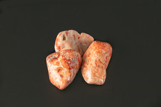 heliolite group nature textured pink stone on black surface