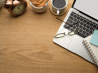 Top view of wooden table with laptop, stationery, decorations and copy space © bongkarn