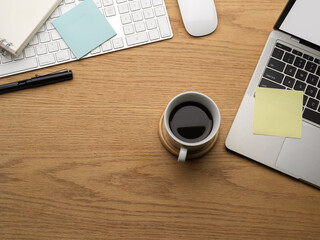 Top view of wooden table with copy space, laptop coffee cup and stationery