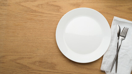 Table Setting Background, mock up ceramic plate, fork and table knife on white napkin, empty ceramic dish