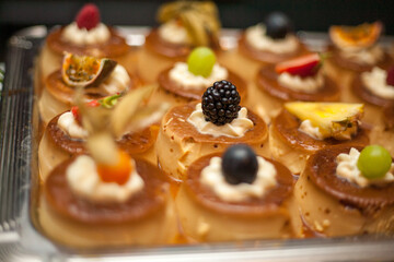 desserts with fruits, mousse, biscuits. Different types of sweet pastries, small colorful sweet cakes, macaron, and other desserts in the sweet buffet. High quality photo