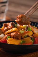Sweet and sour sauced deep fried pork with chopped pepper and pineapple.