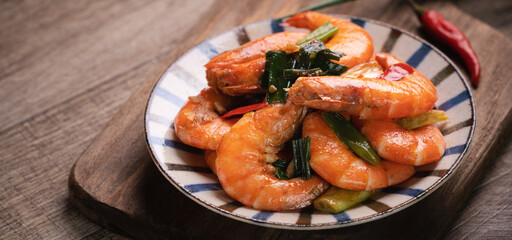 Delicious pan-fried shrimp on dark wooden table background.