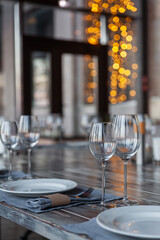 Modern veranda restaurant interior, banquet setting, glasses, plates