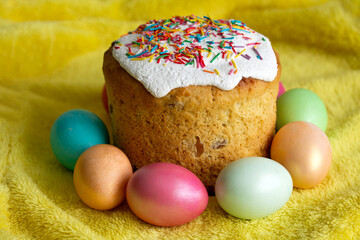 Traditional Slavic Easter cake decorated with sprinkles. Colored chicken eggs. Spring celebration event. Copy space