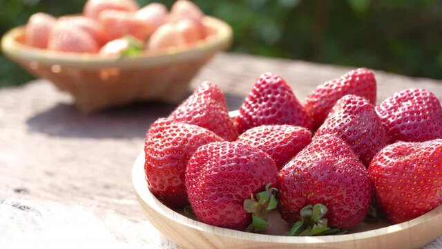 Fresh strawberries with leaves on bamboo basket, Red and White strawberry in Bamboo basket on wooden table.