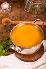Bowl of pumpkin soup on rustic wooden background