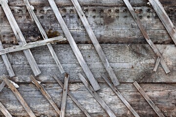 Background texture of an old timber wall with the remnants of a slatted lathing.
