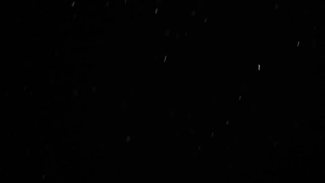 Falling snowflakes on night sky background, isolated for post production and overlay in graphic editor. Bokeh of white snow on a black background hd slow motion video.