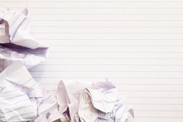 Empty lined paper with crumpled balls of paper beside; Mistakes and fresh start in writing