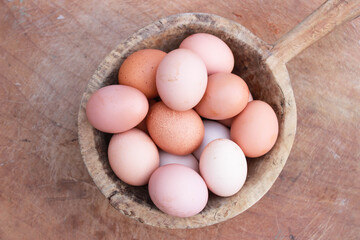 Eggs in wooden bowl with wooden background for healthy and organic food. Copy space for your text.