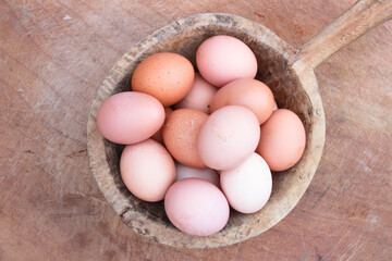 eggs on the wooden bowl and wooden table background. Top view.
