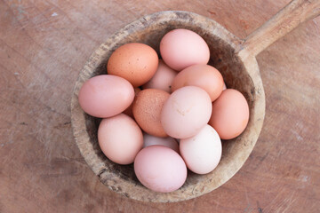 Eggs in wooden bowl with wooden background for healthy and organic food. Copy space for your text.