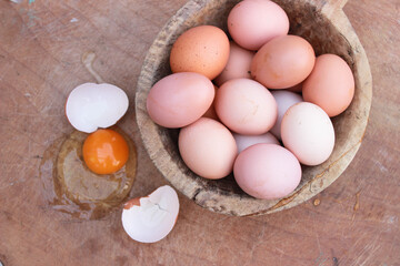 a broken egg and intact eggs, yolk and egg whites on wooden background. Copy space for your text. selective focus
