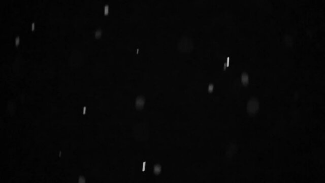 Falling snowflakes on night sky background, isolated for post production and overlay in graphic editor hd slow motion video. Bokeh of white snow on a black background.
