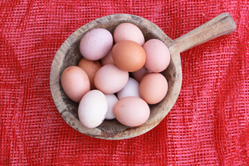 eggs in wooden bowl and red background, top view. Copy space.selective focus.