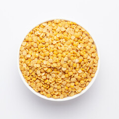 Close up of Organic arhar dal (Cajanus cajan) or split yellow dal on a ceramic white bowl. Top view 