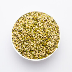 Close up of Organic green Gram (Vigna radiata) or spilt green moong dal un polished on a ceramic white bowl. Top view 