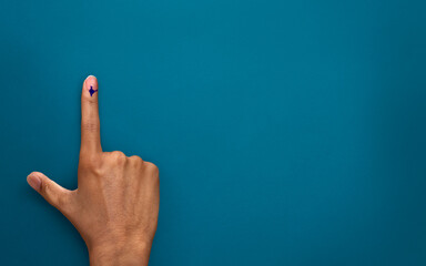 male Indian Voter Hand with voting sign or ink pointing vote for India on background with copy...