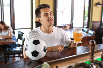 Young man placing sports bet in pub