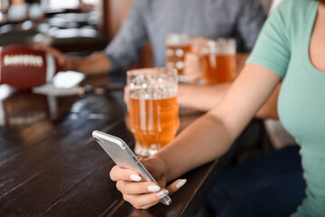 Young woman placing sports bet in pub