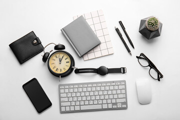 Composition with modern smart watch, computer keyboard, mobile phone and alarm clock on light background