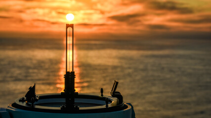 Direction finder of ocean going vessel on sunset background 