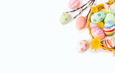 Fototapeta na wymiar Colorful Easter eggs with yellow flowers and willow twigs on white background. Top view.