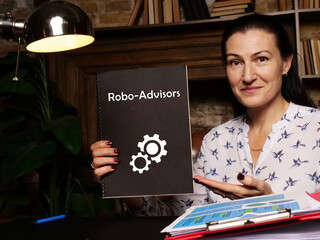 Business concept meaning Robo-Advisors with phrase on blank notepad in hand.
