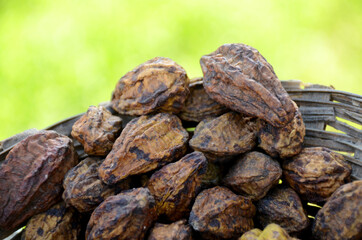 bunch the brown drilled ha-rad fruit on the green background.